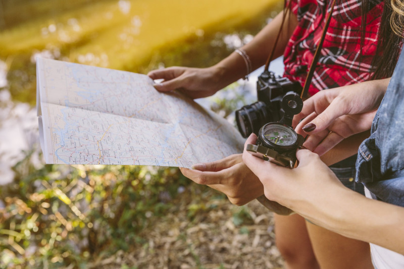 close-up-two-female-friend-holding-compass-map-96-195